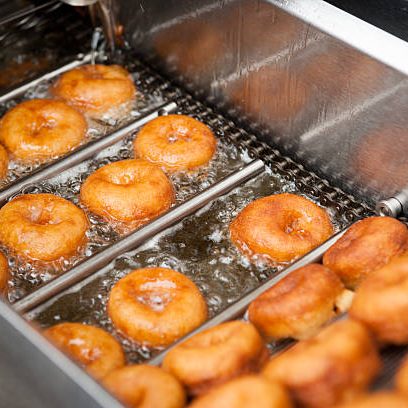 Deep frying doughnut machine close up